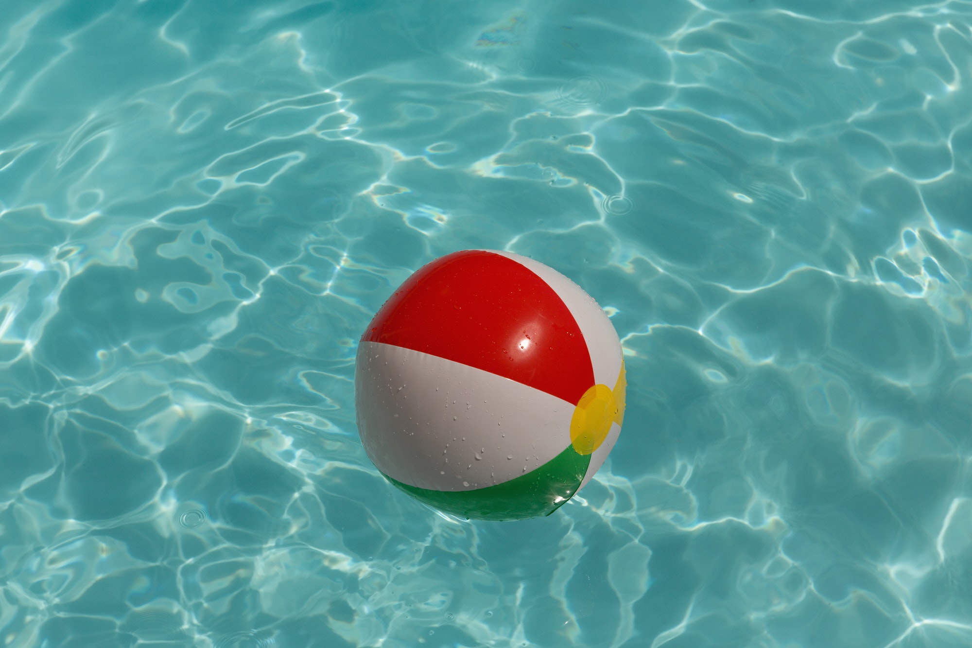 Inflatable ball floating in swimming pool on a sunny day